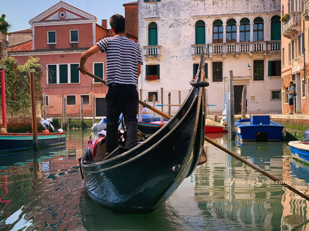 Gondoliere fährt durch venezianischen Kanal